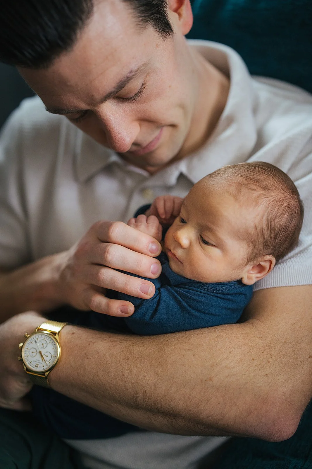 Father holds baby at an in-home newborn photoshoot in Durham, NC
