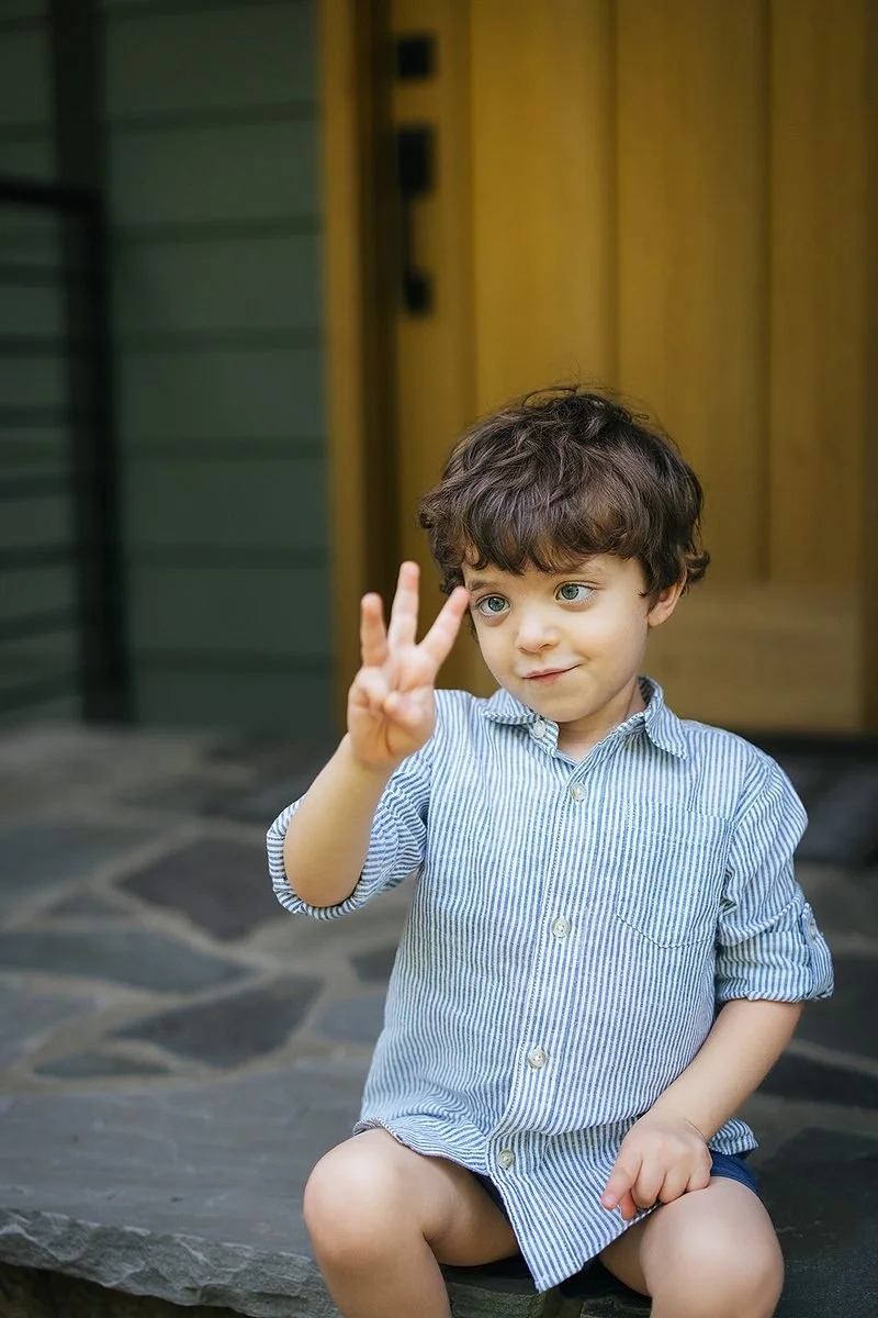 Toddler boy holding up three fingers