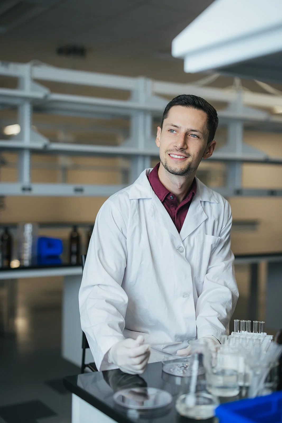 ManInWhiteLabCoatWorkingInLabLookingOutWindow