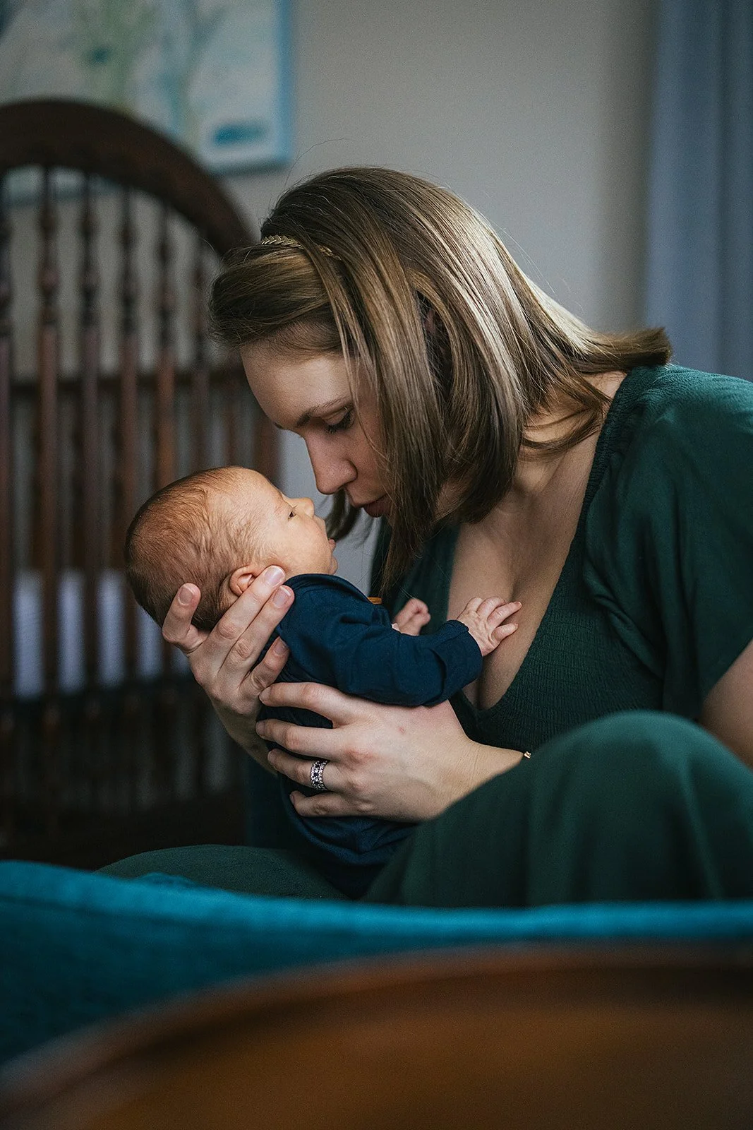 Mother holds newborn baby with eyes closed at a newborn photo session in Durham, NC