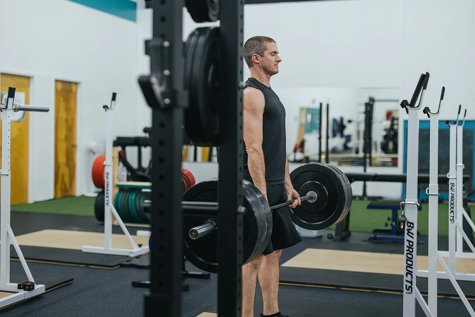 man lifts heavy weights at Durham, NC wellness center for local business photography