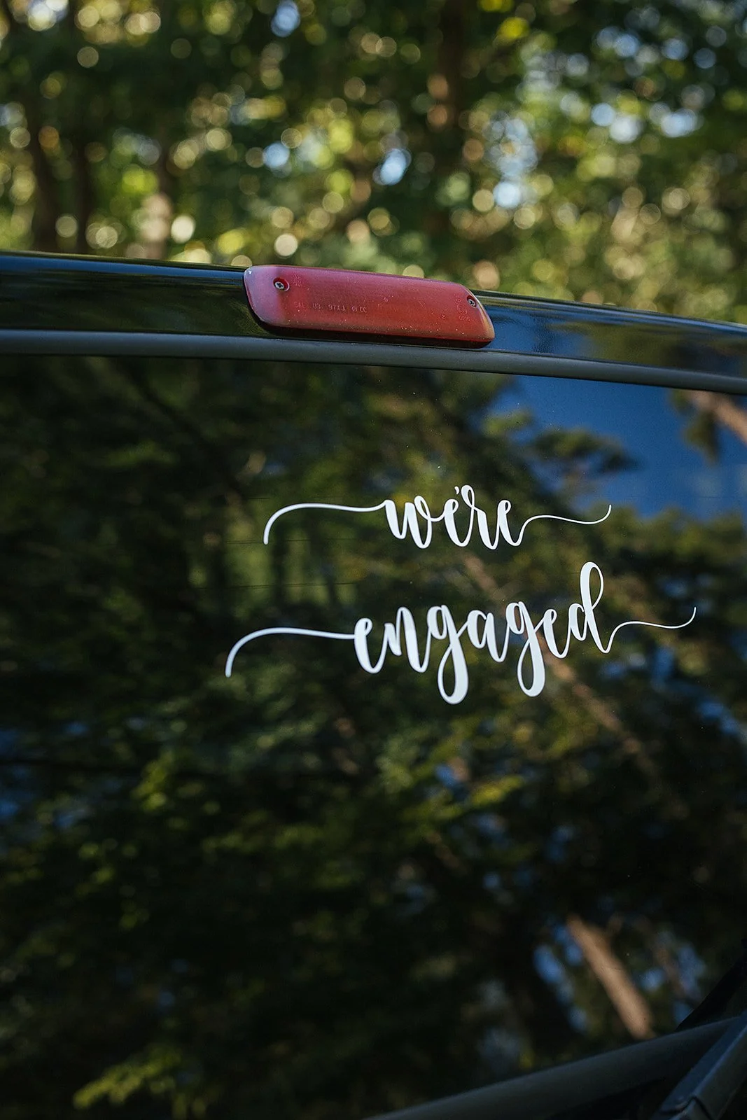 We're engaged written on the back of a car