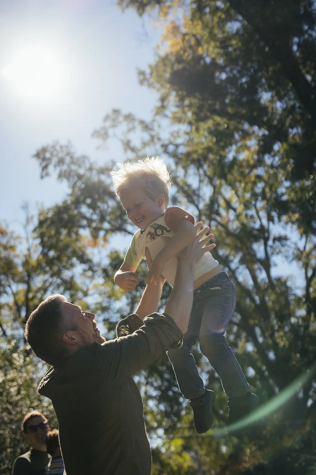 Dad Thowing Young Child in Air During Family Photo Session