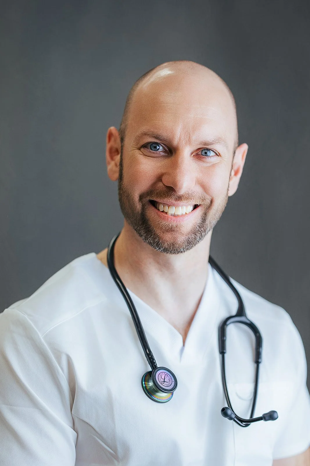 Durham Tech nursing student with warm smile in white scrubs and black stethoscope, professional headshot by Fifty Two Hundred Photography in Durham NC