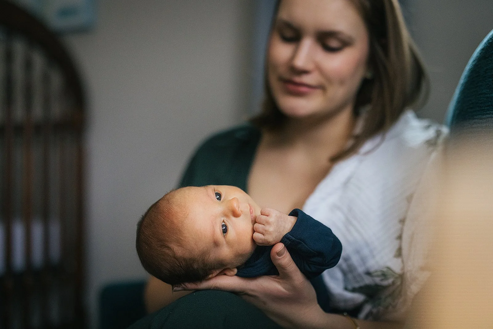 Mother holds newborn baby at an indoor newborn photoshoot in Durham, NC