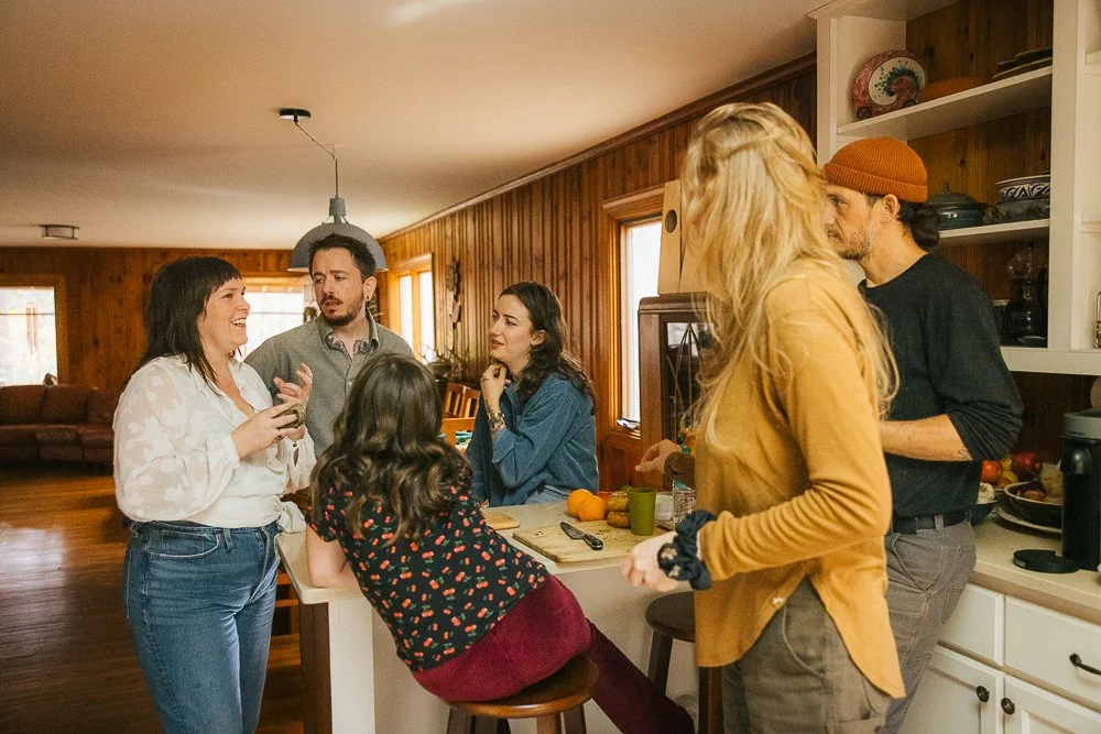 Friends Sitting Around Kitchen Counter Eating and Chatting