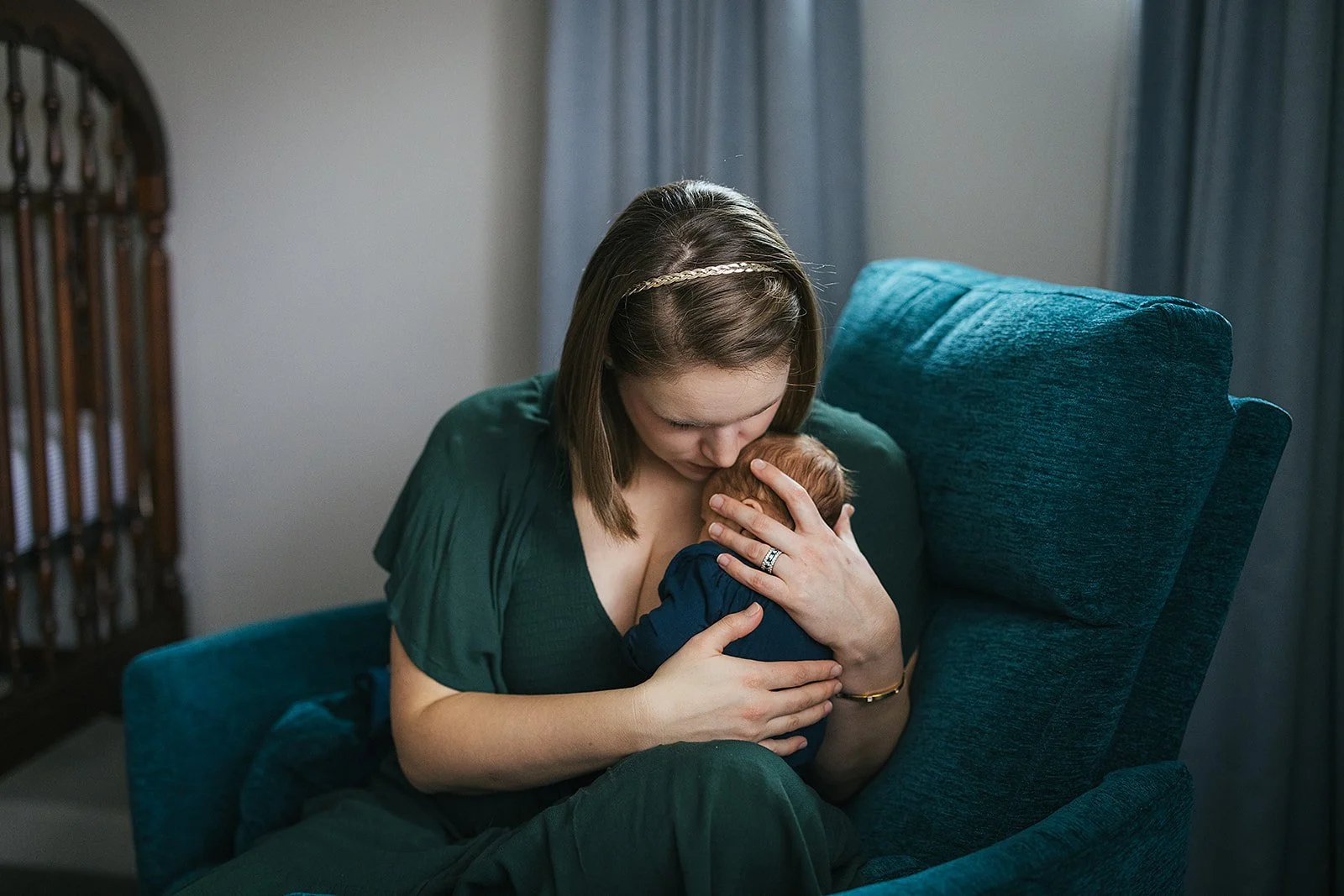 Mother holds baby close in rocking chair at a newborn photoshoot in Durham, NC