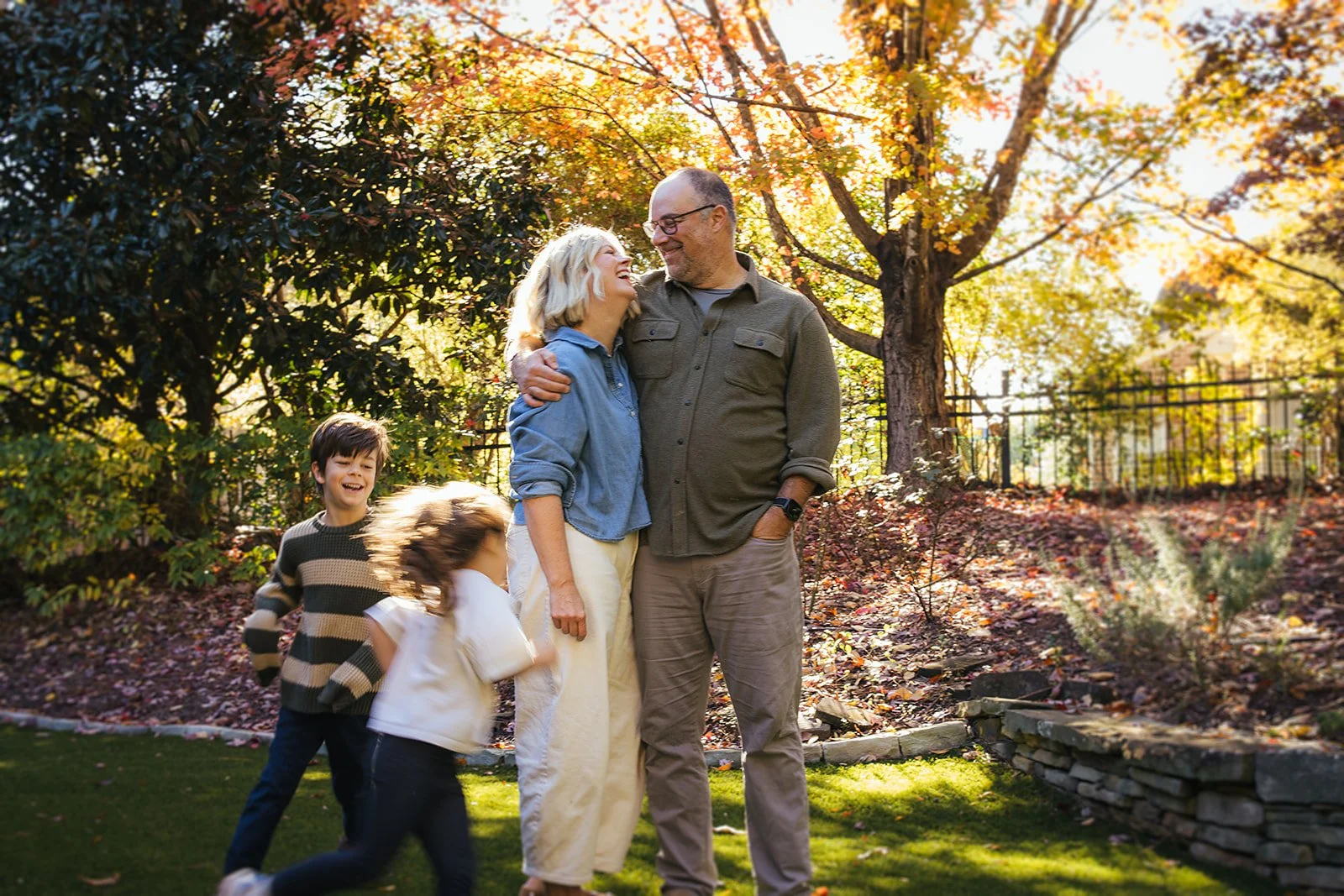 Parents and Laughing and Smiling While Kids Run in Backyard