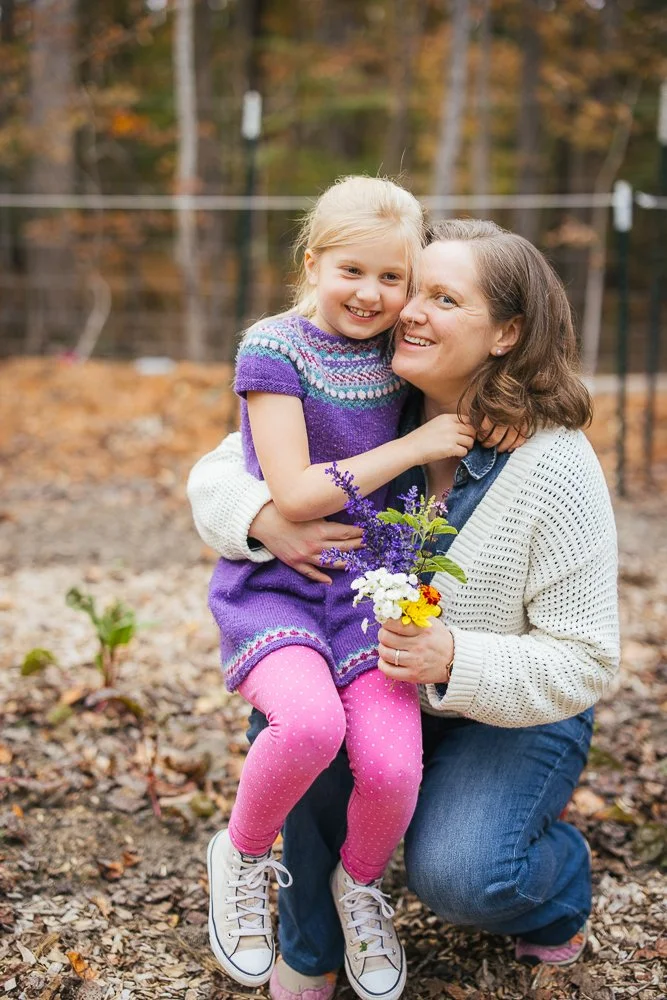 Mom holding daughter and flowers she picked
