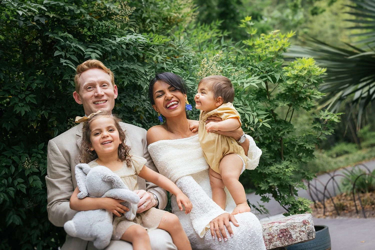 Family of four smiles and laughs during a family photoshoot at Duke Gardens in Durham, NC