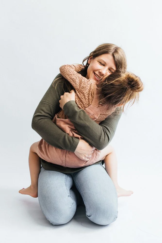 MomSittingAndHuggingYoungGirl