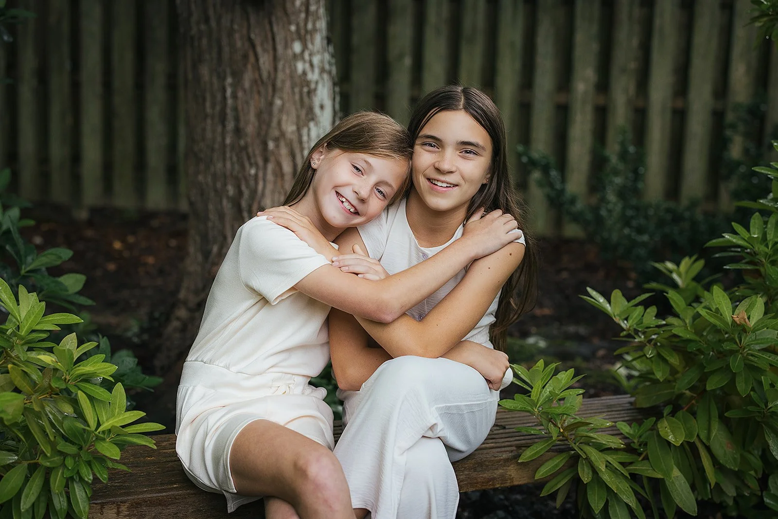 Sisters hugging in back yard Fifty Two Hundred Photography