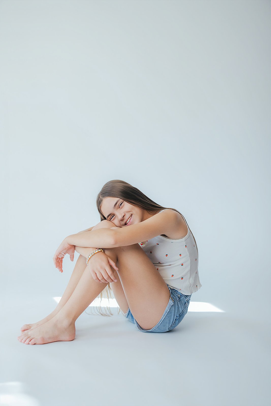 Young Girl Sitting Down in Front of White Wall Childhood Studio Portrait Durham NC