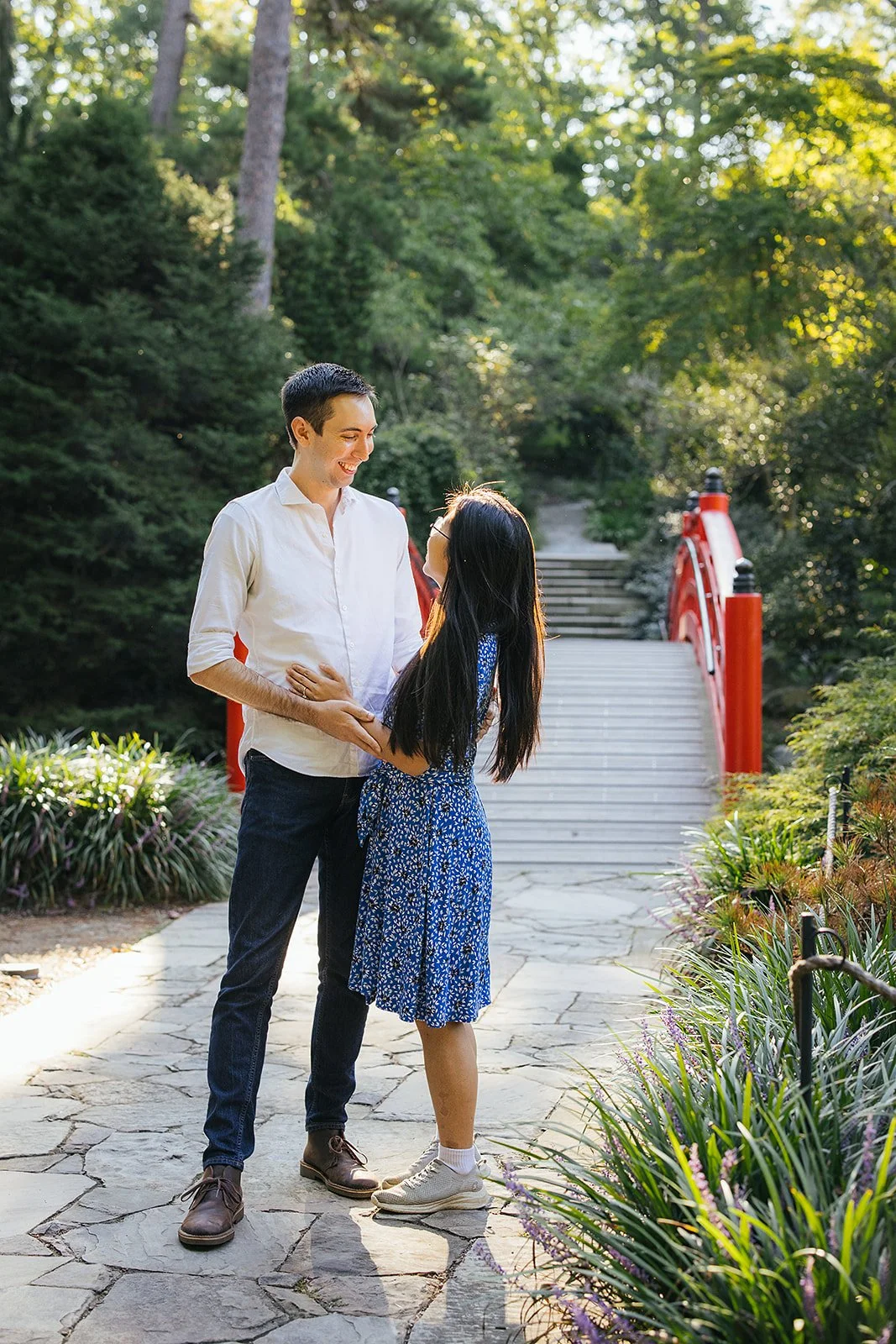 A couple smiling after their surprise engagement during a photoshoot at Duke Gardens in Durham, NC