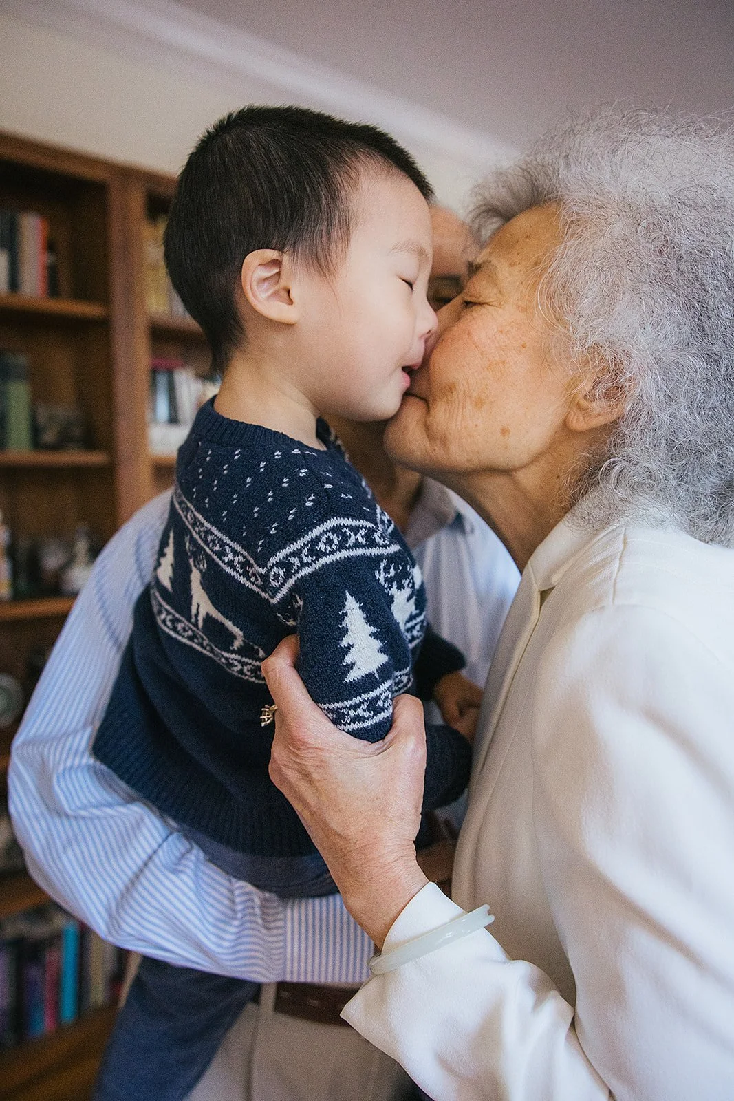 Grandmother kissing young boys face