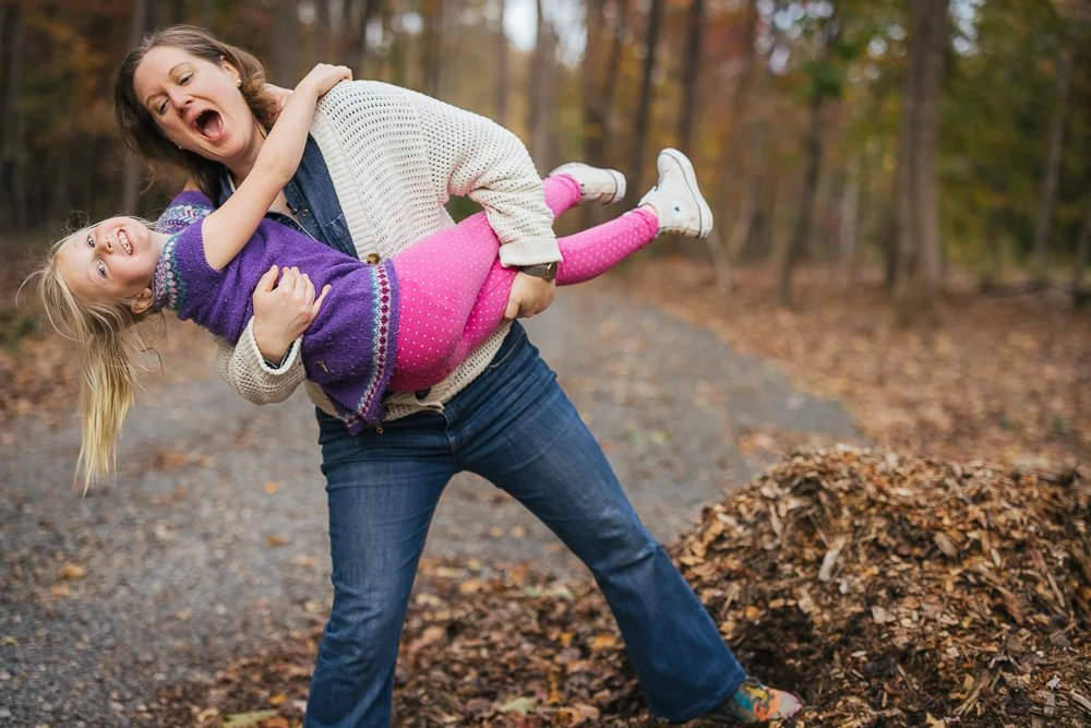 Mom holding and laughing with daughter in Durham NC backyard