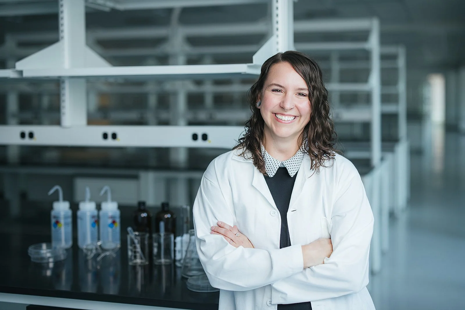 WomanSmilingArmsCrossedInScienceLab