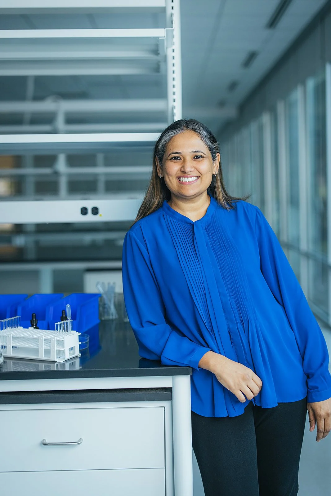 WomanInBlueShirtLeaningOnLabTable