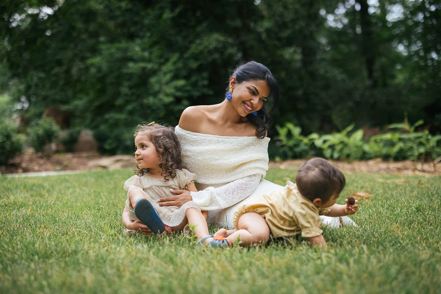 mother with two children play in the grass during a duke gardens family photoshoot in Durham, NC