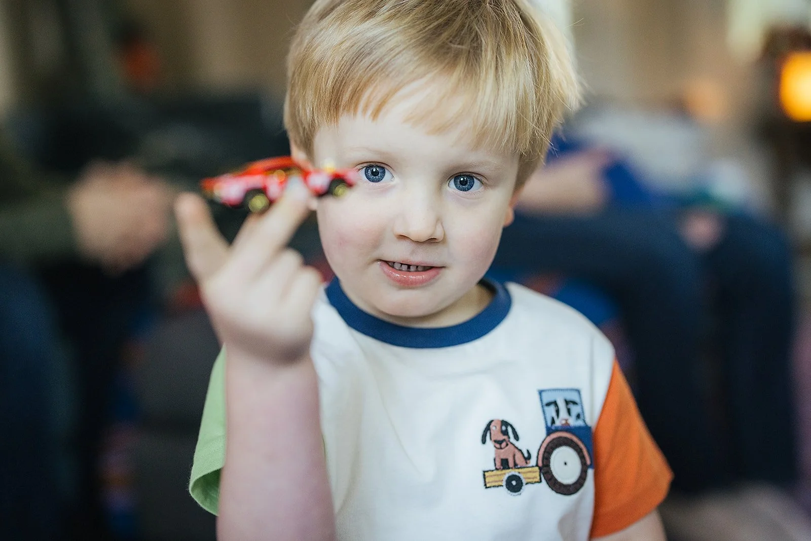 Young Boy Holding Red Toy Car During In-Home Family Photo Session