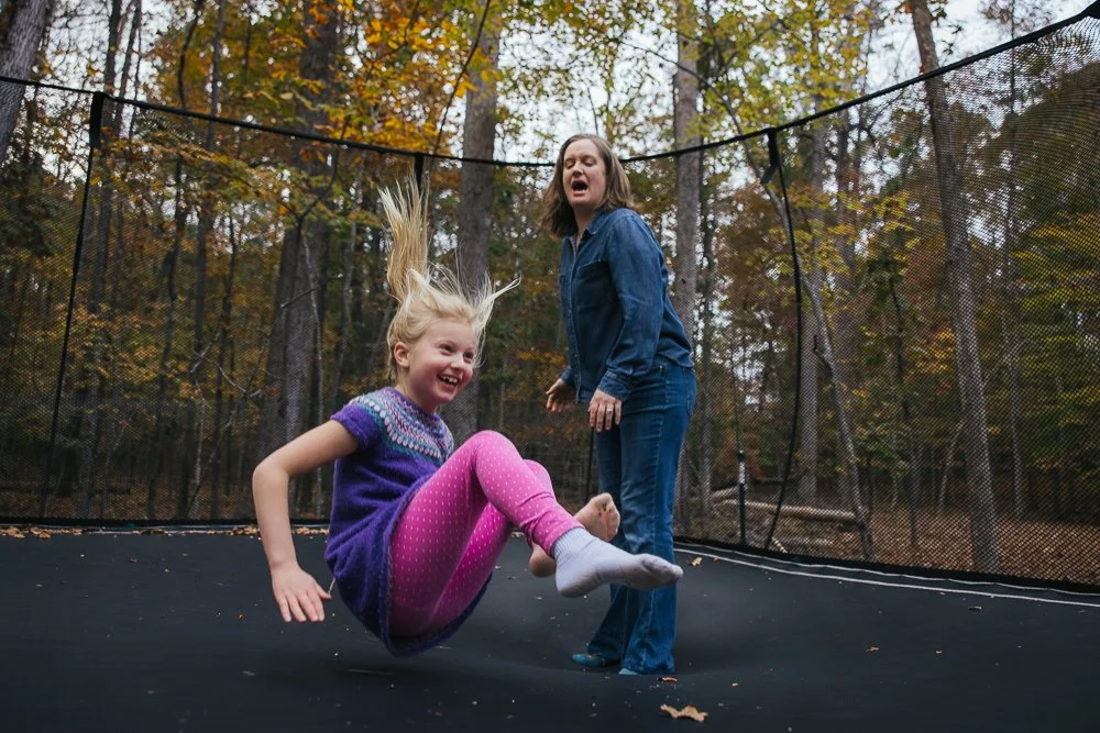 Mom jumping on trampoline with daughter