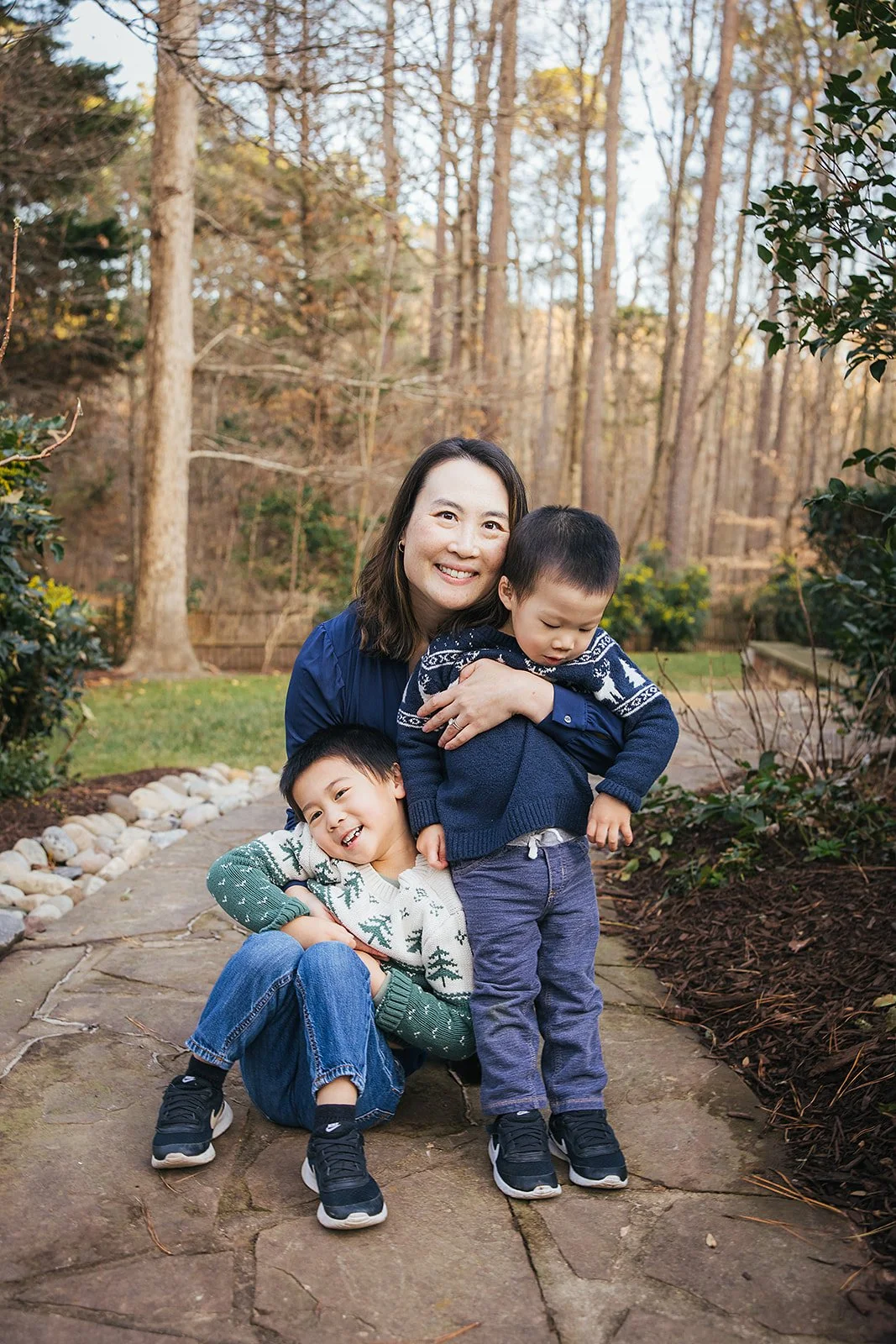 Mother with two young sons outside on sidewalk