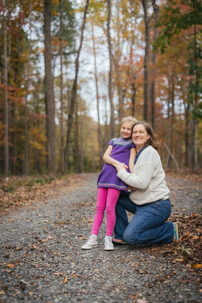 Mom and daughter smiling on trail in woods in Durham NC