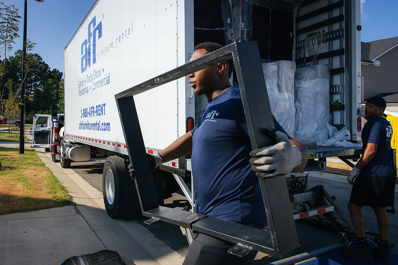 AFR Furniture Rental team moving furniture into a Durham home during a commercial photography session