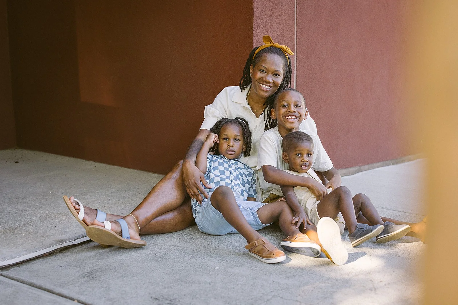 Family of four sits on a corner in Durham NC for a family photoshoot