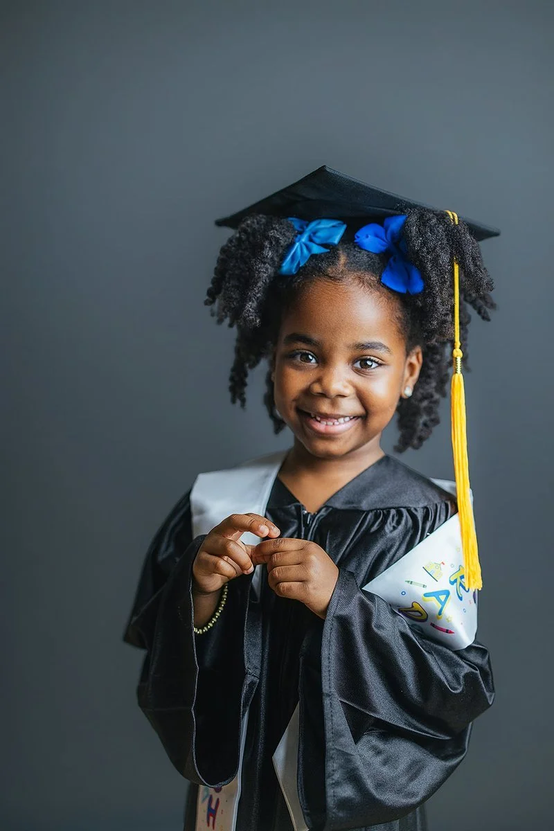 Young Girl in Graduation Cap and Gown Smiling at Durham Preschool