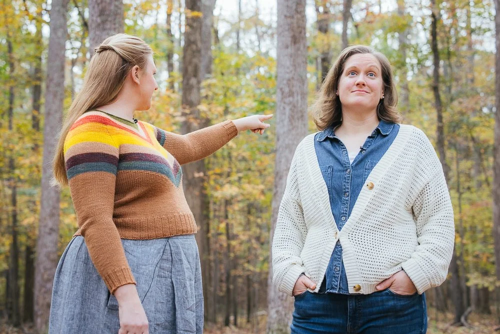 Two women standing in wooded backyard