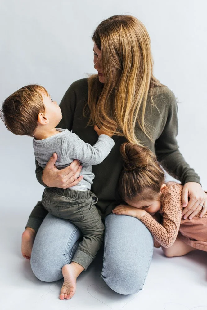 MomSittingAndSnugglingTwoKids