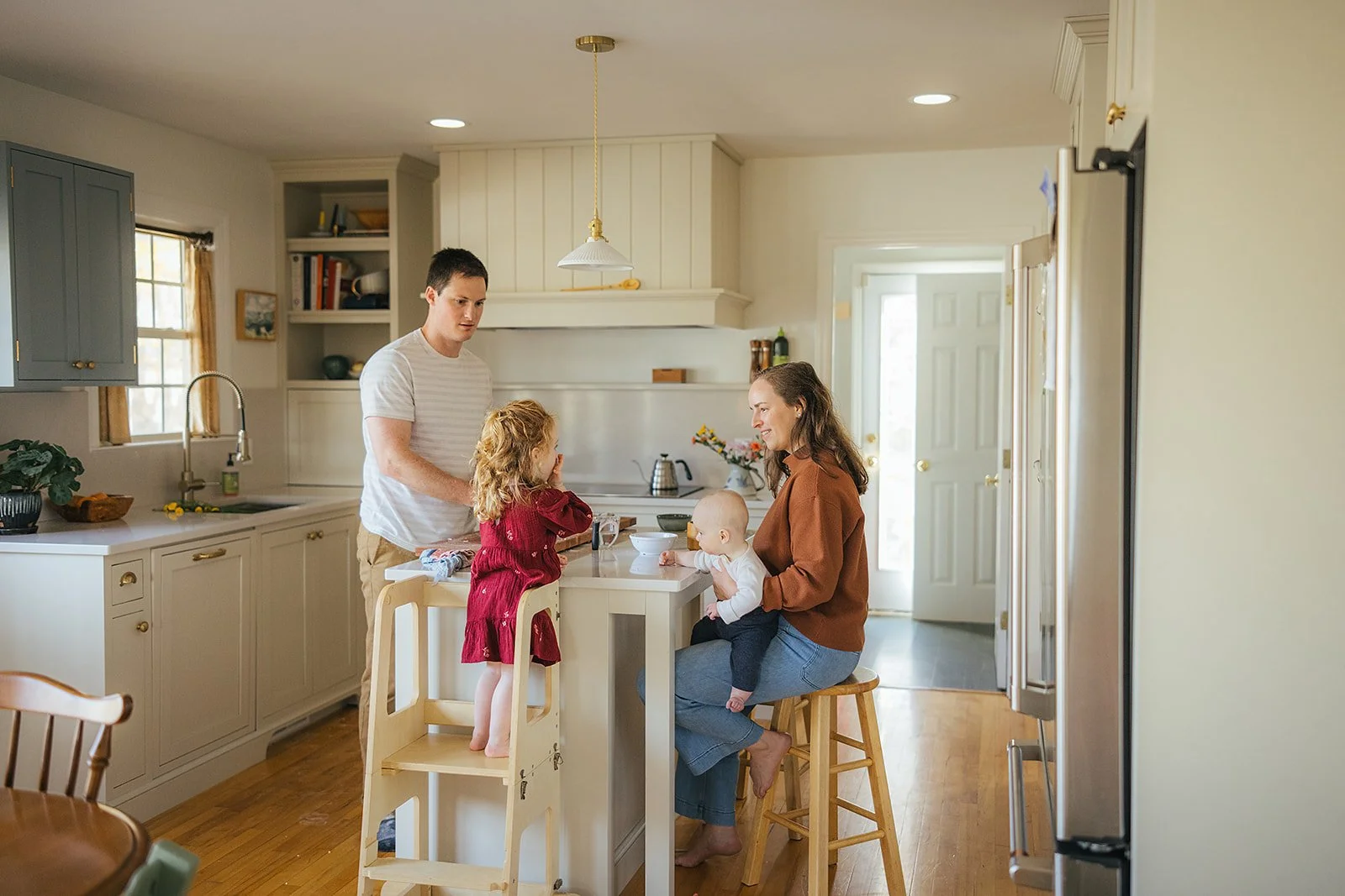 Whole family gathers around kitchen island during morning routine captured by Durham family photographer