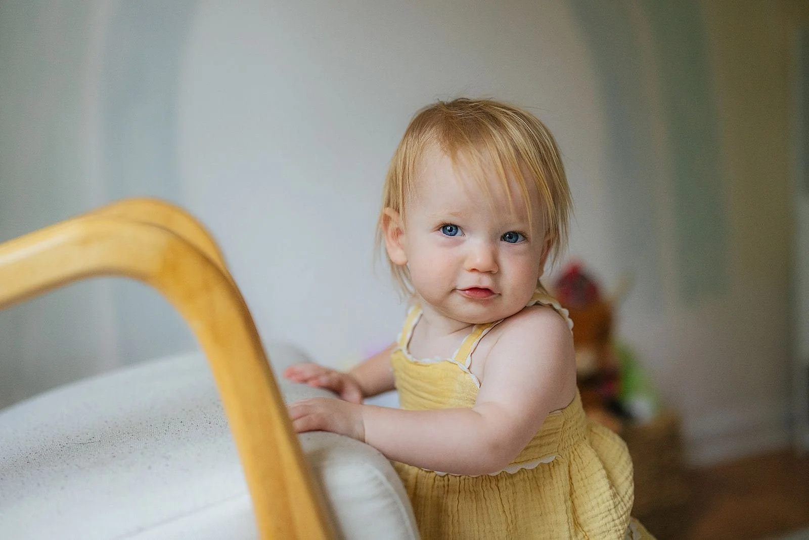 Young Girl Pulling Up On Chair to Stand During Photography Session