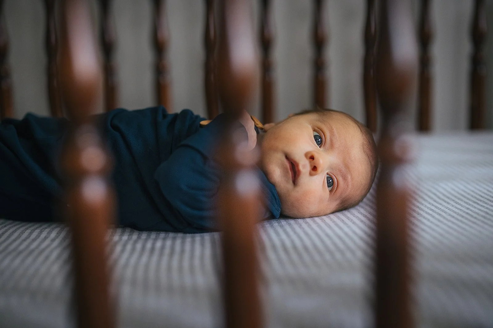 Newborn baby in a crib for an in-home photoshoot in Durham, NC