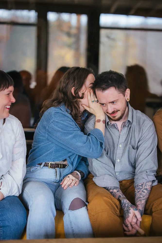 Woman Whispering in Man's Ear During In-Home Family Photography Session