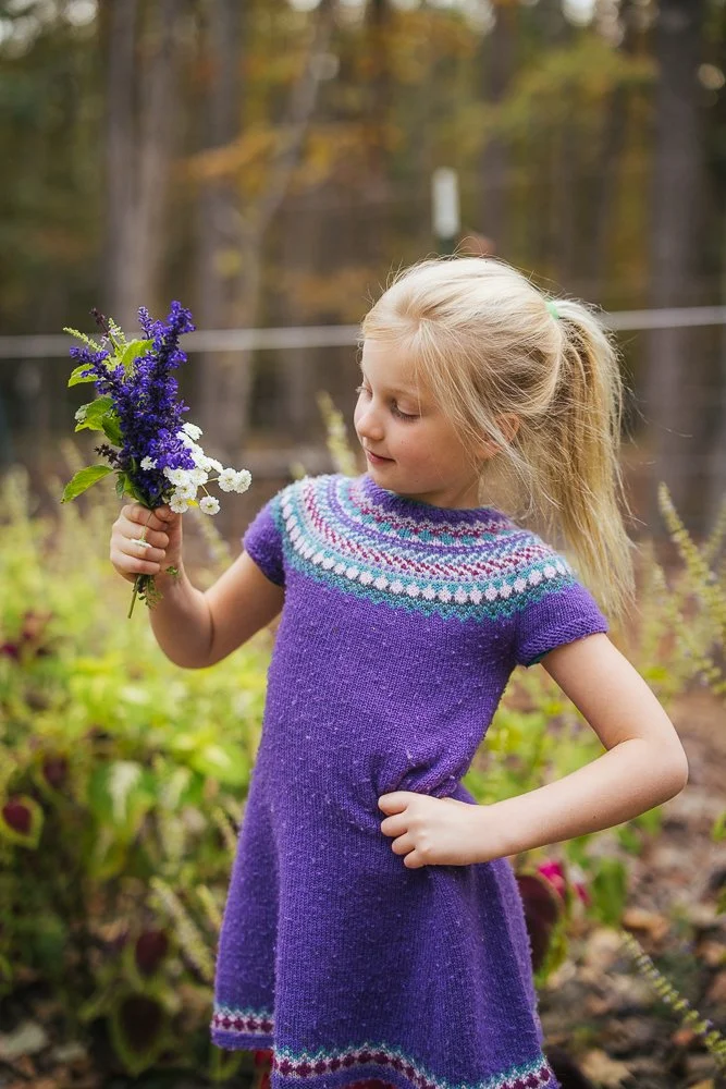 Young girl wearing flowers she picked in backyard