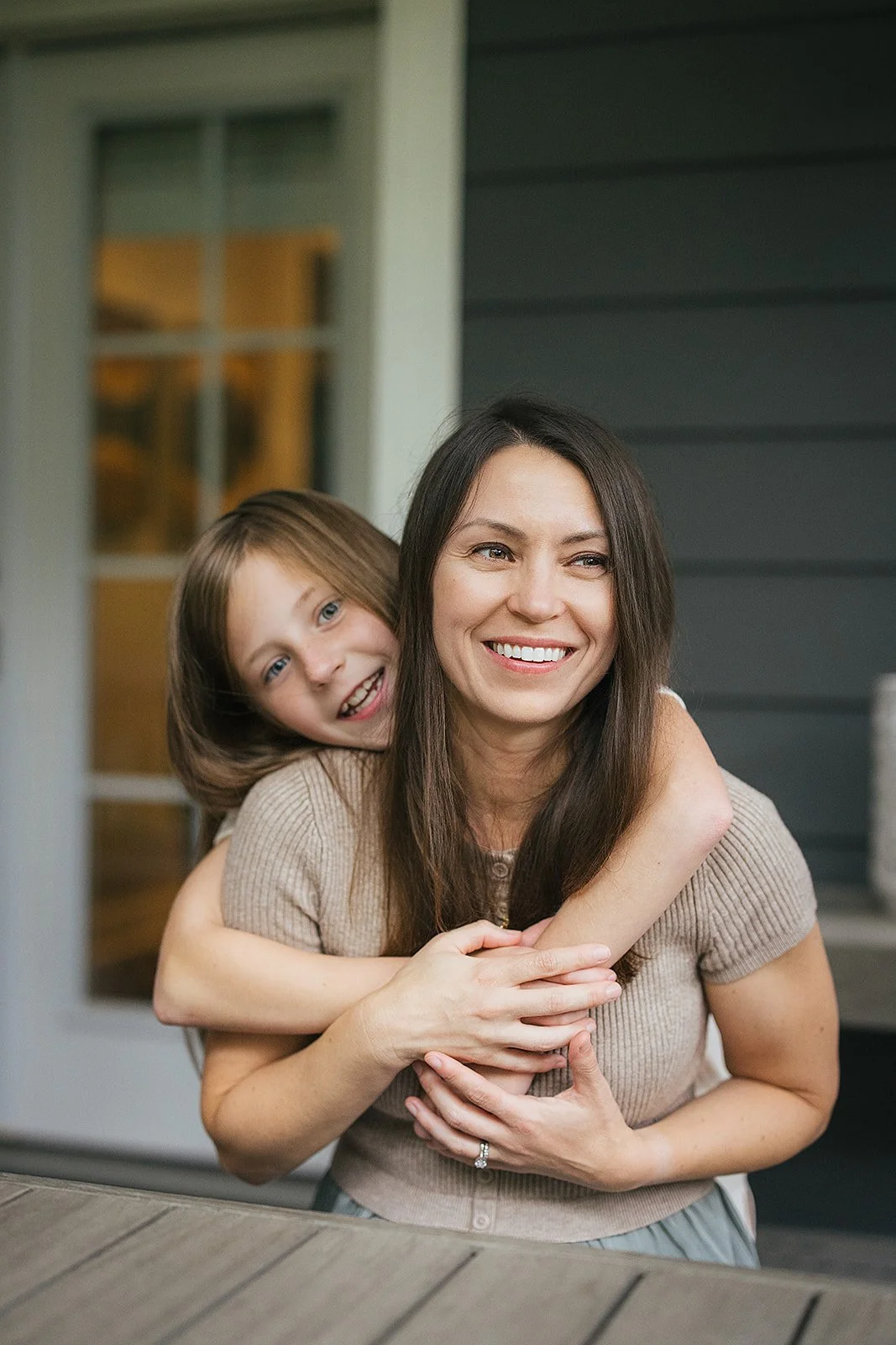 Mom and daughter on porch in-home family photography session