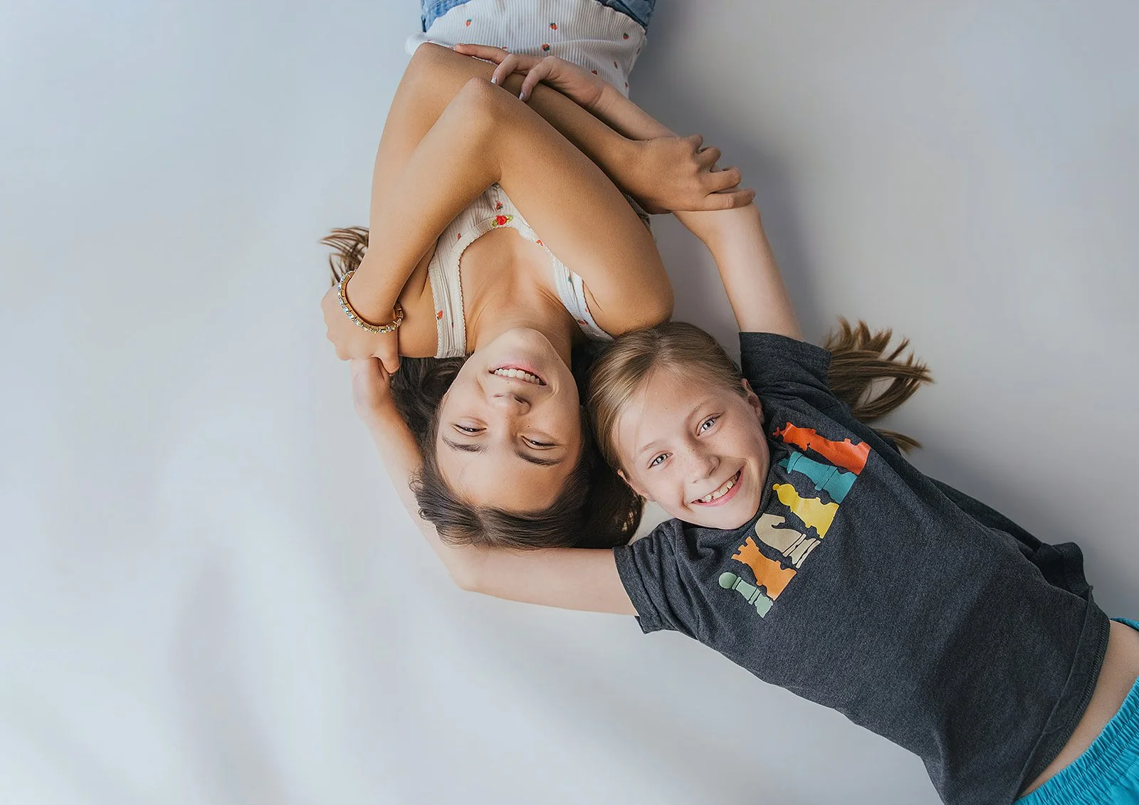 Sisters Laying on Ground Together Studio Portrait Session Durham NC
