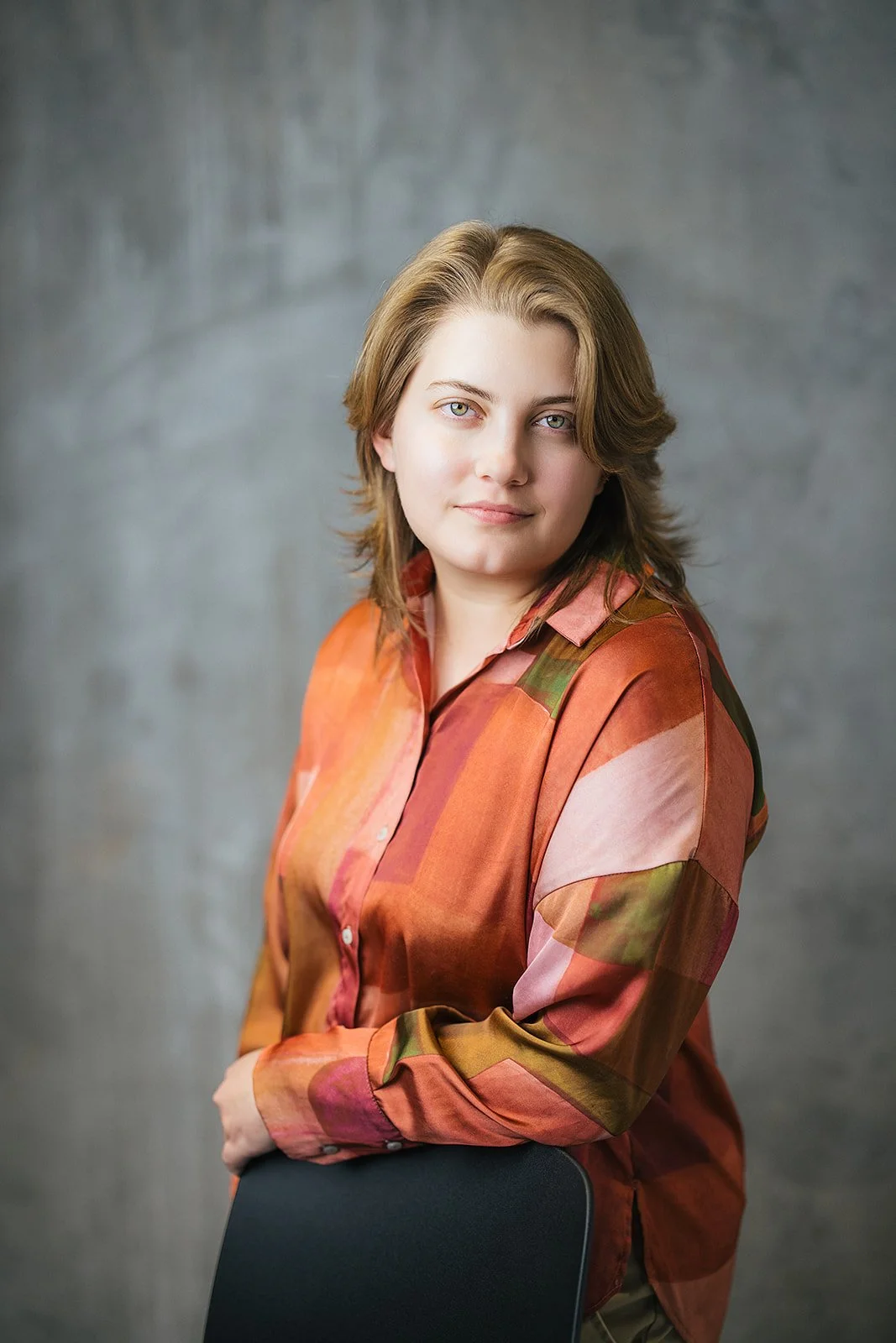 Woman in Orange Blouse Smiling During Headshot Session
