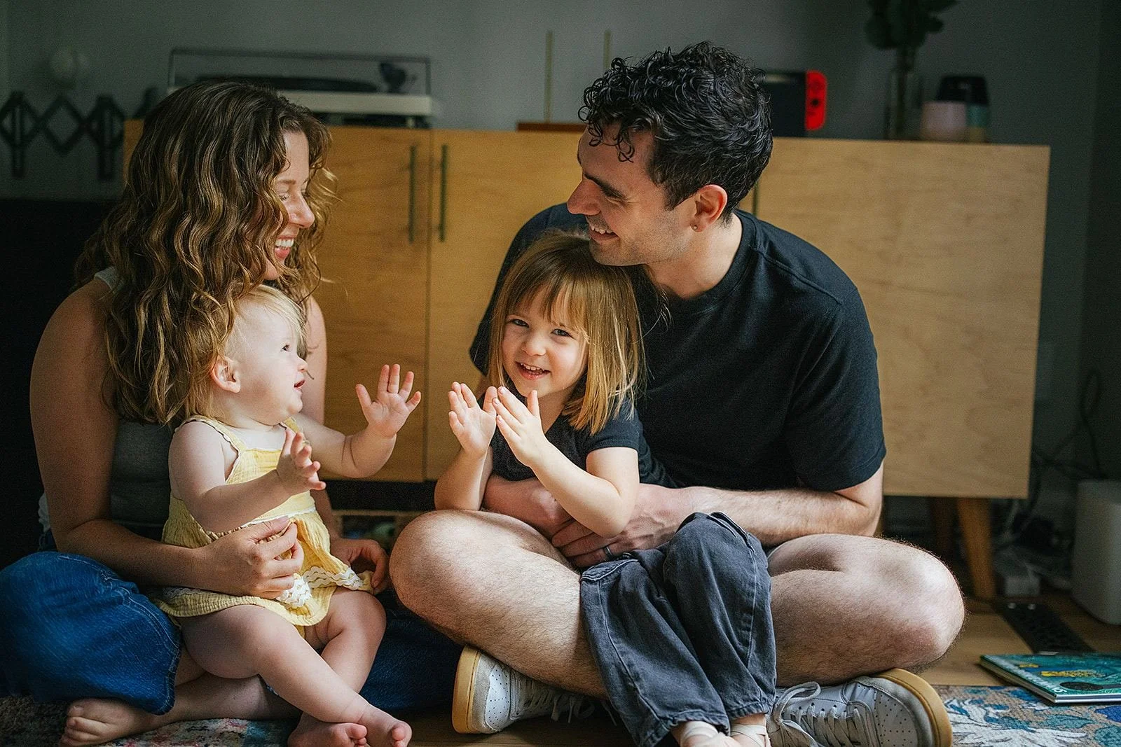 Family Sitting On Living Room Floor and Playing Together In-Home Family Photography Session