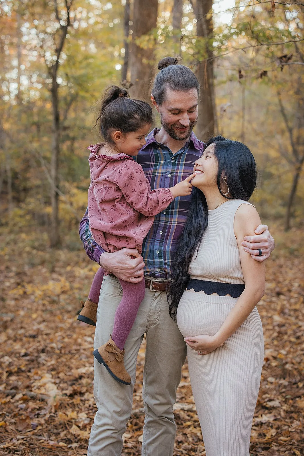 a loving family with one child poses for family photos at the Eno River