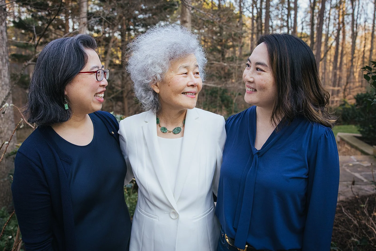 Adult daughters smiling lovingly at mother family portrait session Durham NC