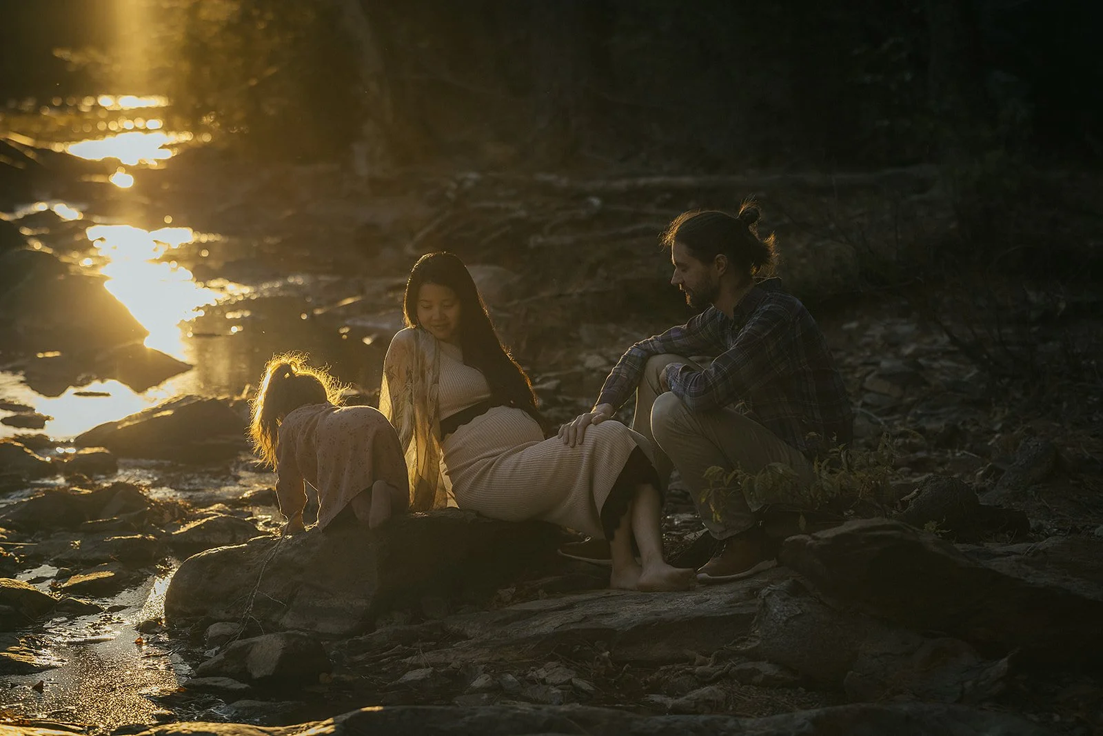 A family together on the Eno River at a maternity photoshoot in Durham, NC