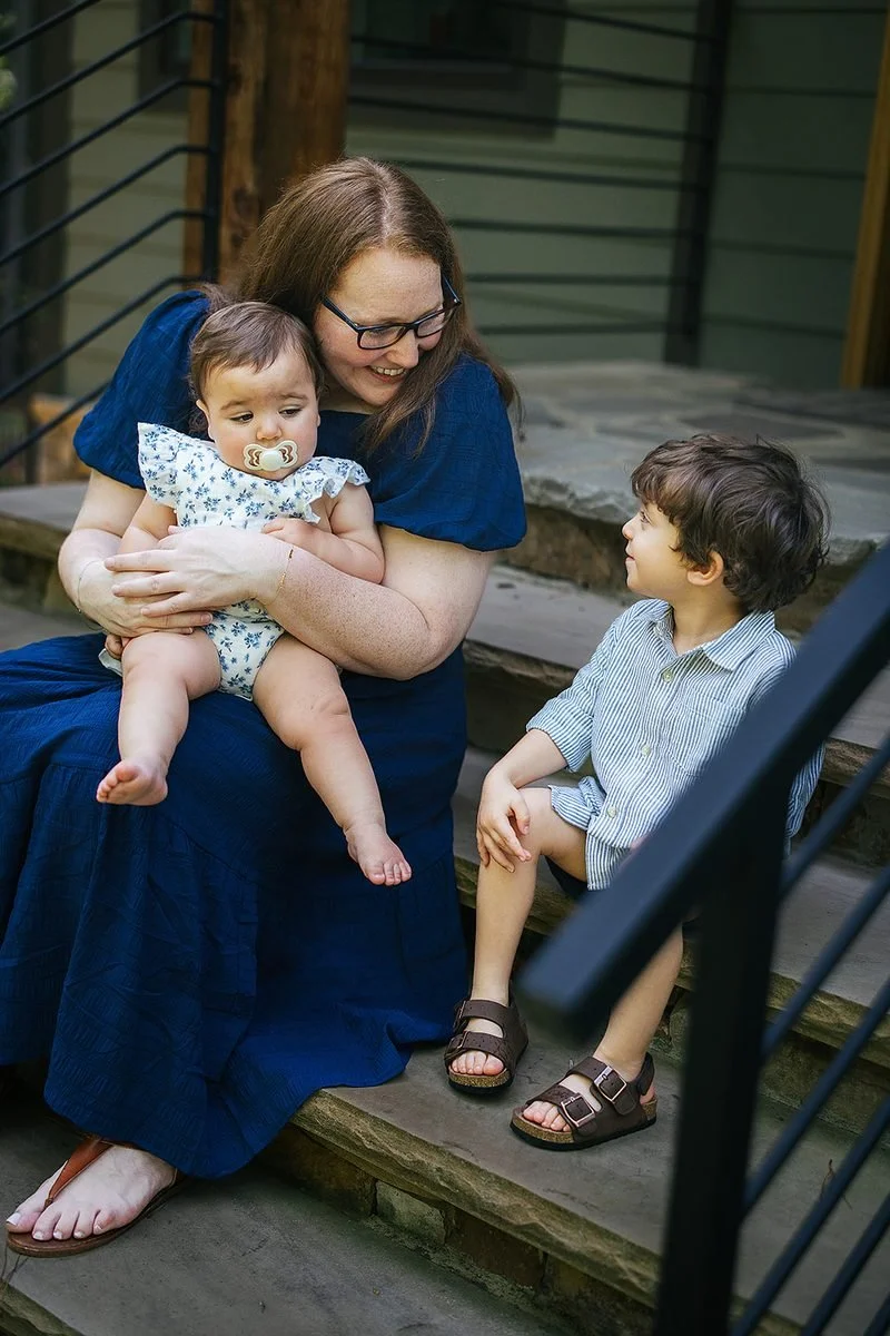Mom sitting with two kids on front porch during family phtoo session