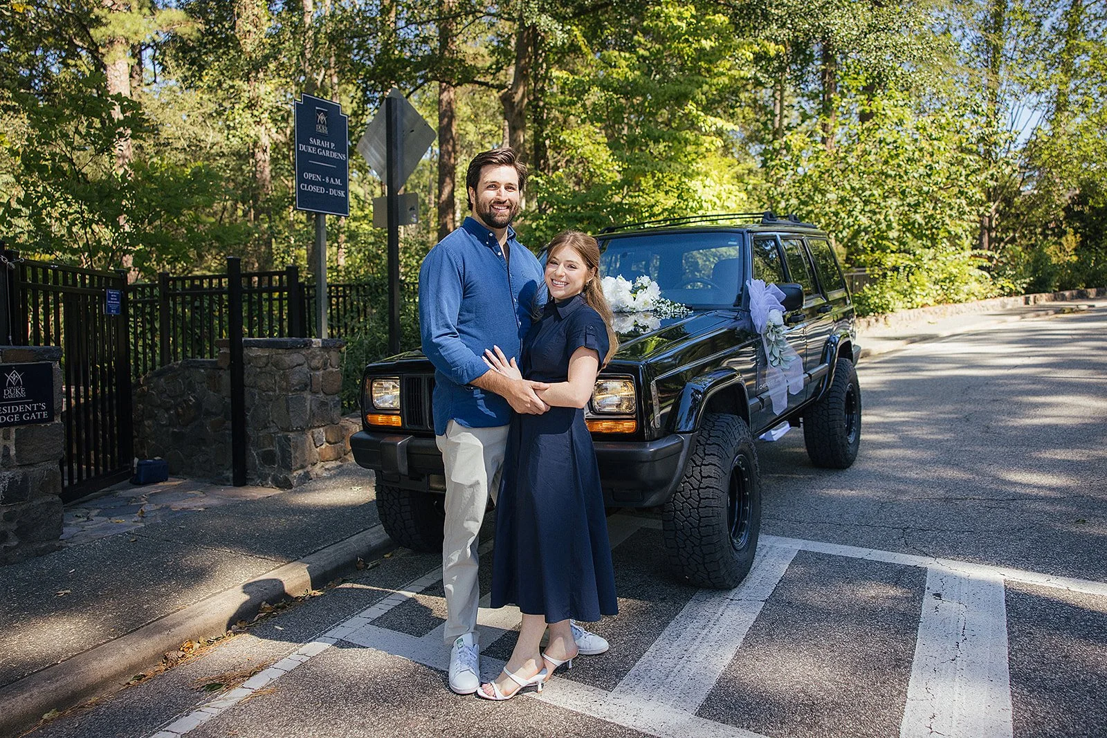 Couple posing in front of decked out car post engagement