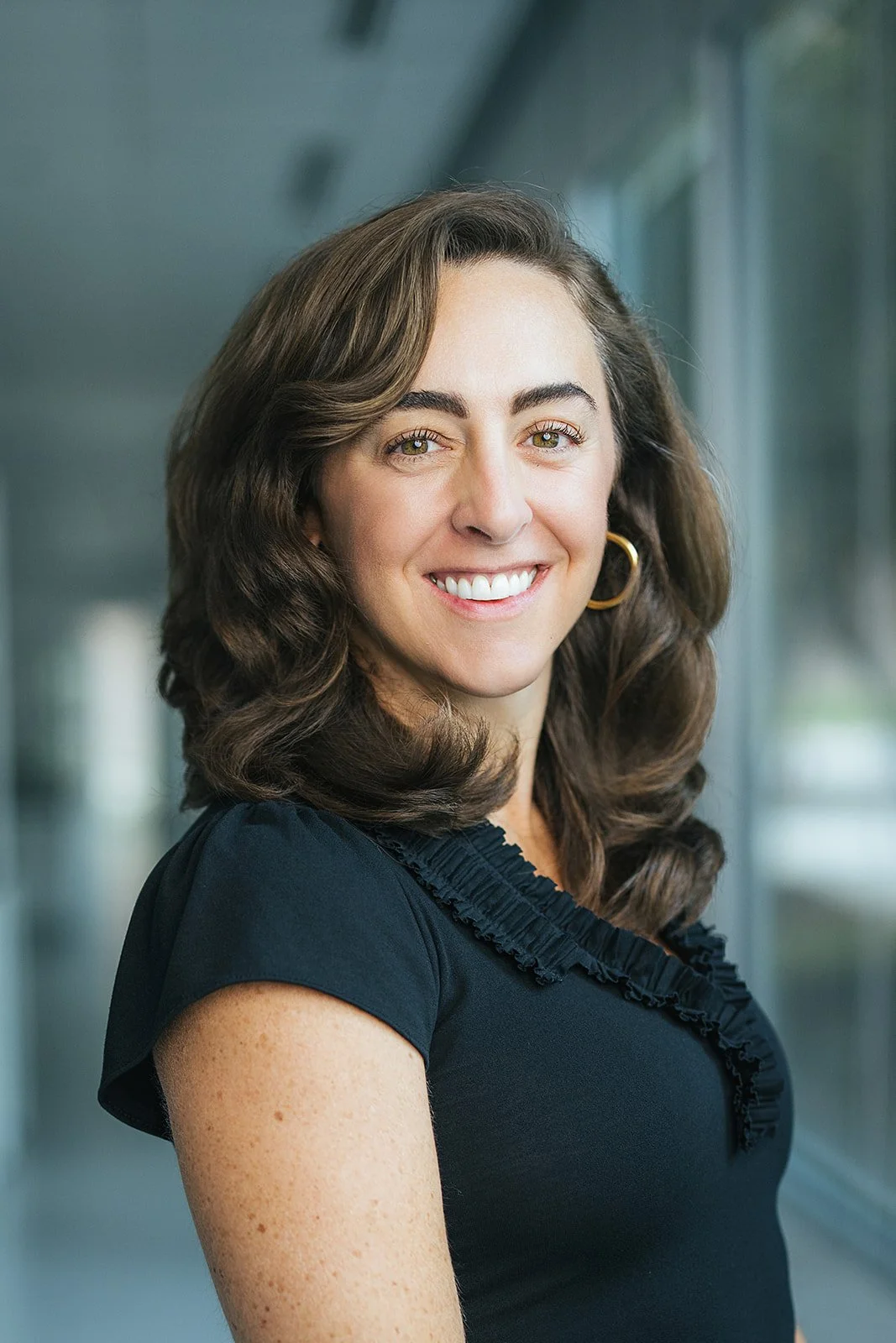 WomanSmilingHeadshotBlackShirt