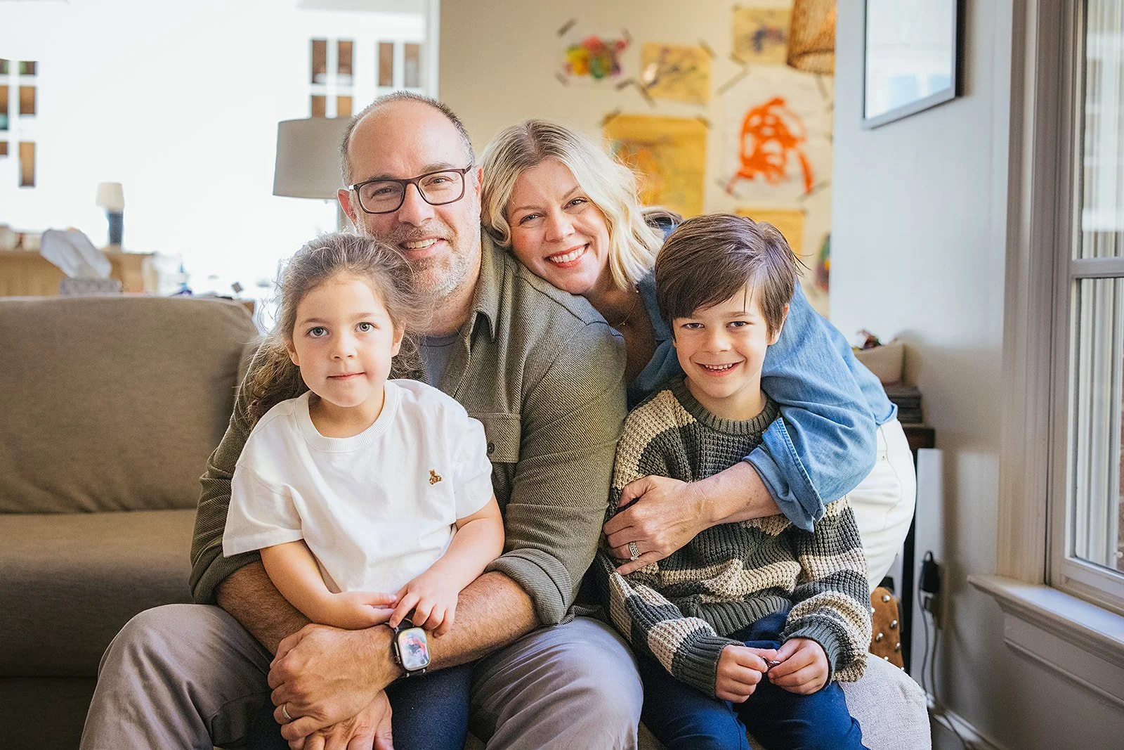 Family of Four Sitting Together in Living Room During In Home Family Photo Session