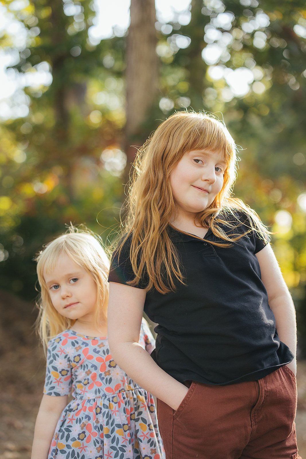 Two Young Girls Smiling Outside During Family Photo Session