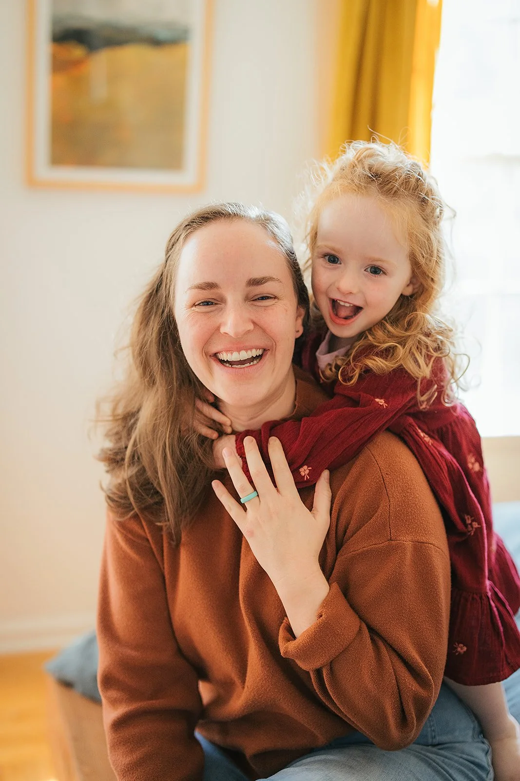 Mom laughs joyfully with toddler daughter during Durham in-home lifestyle family photography session